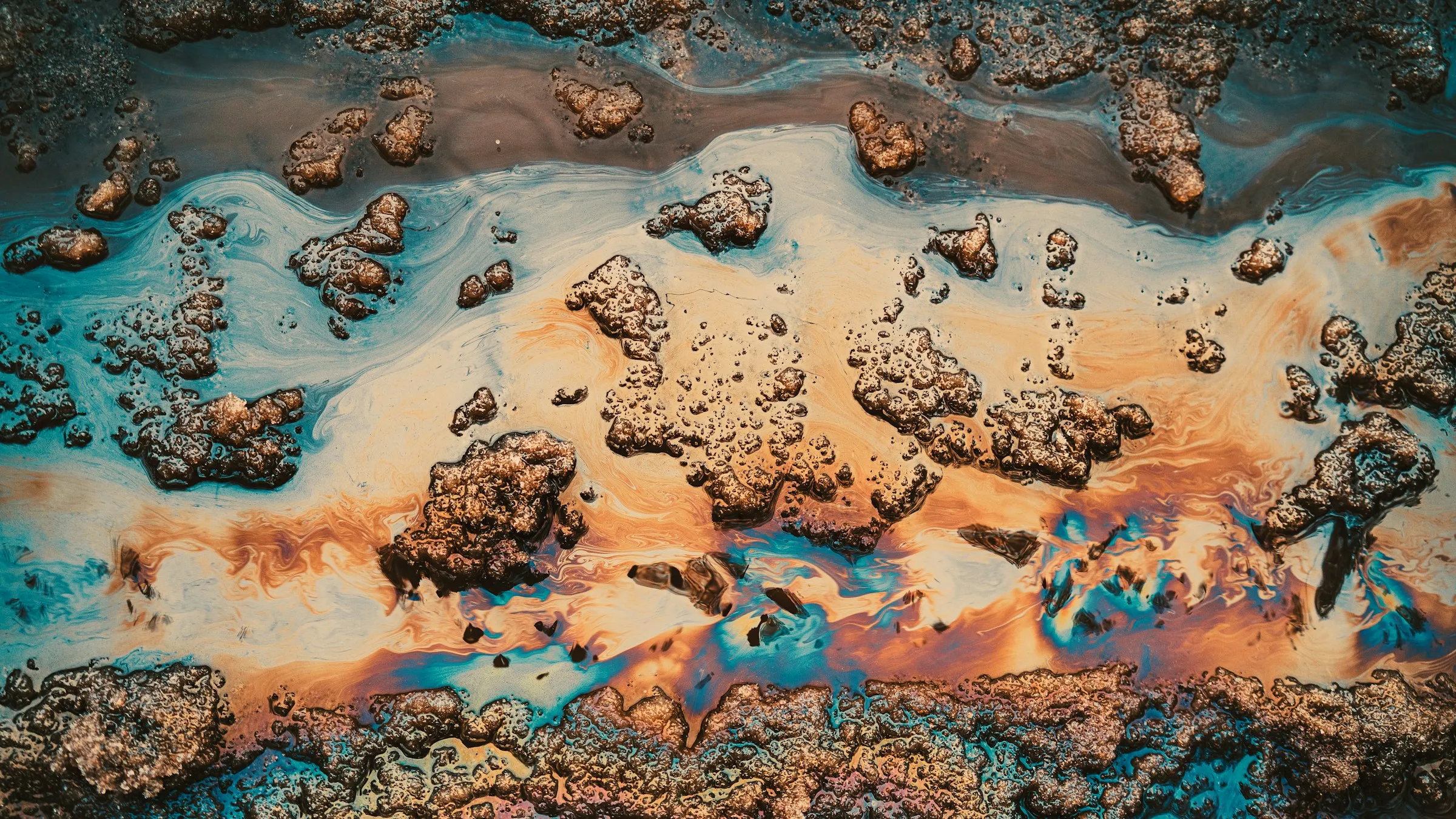 Hydrocarbon film spreading across a water surface, seen from directly above